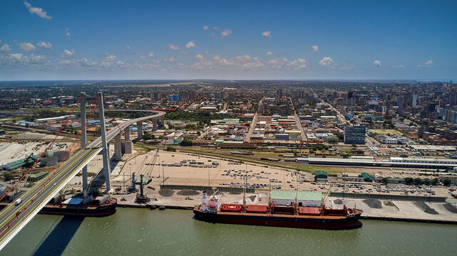 Mozambique, Katembe, Aerial view of two container ships sailing under Maputo-Katembe Bridge with city in background