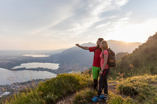Young couple in the mountains, looking at view