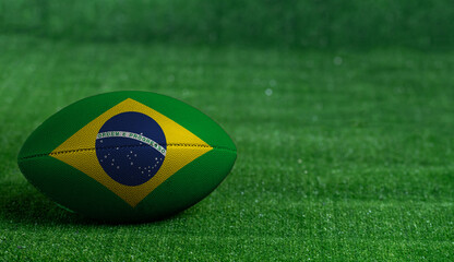 American football ball  with Brazil flag on green grass background, close up