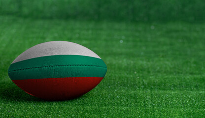 American football ball  with Bulgaria flag on green grass background, close up