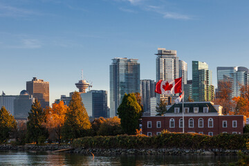 Downtown Vancouver modern Coal Harbor business district area high office and apartment buildings with Naval Museum with a large Canadian flag and fall foliage autumn