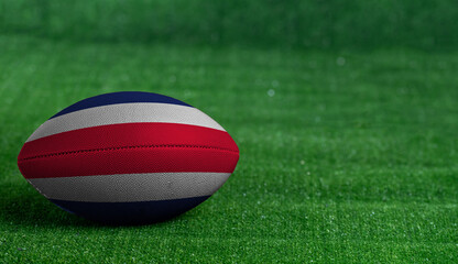 Fototapeta na wymiar American football ball with Costa Rica flag on green grass background, close up