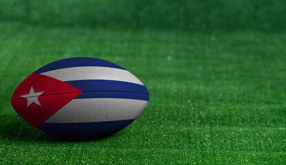 Plakat American football ball with Cuba flag on green grass background, close up