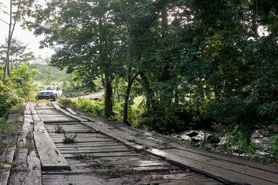 Costa Rica, Car driving toward simple wooden bridge