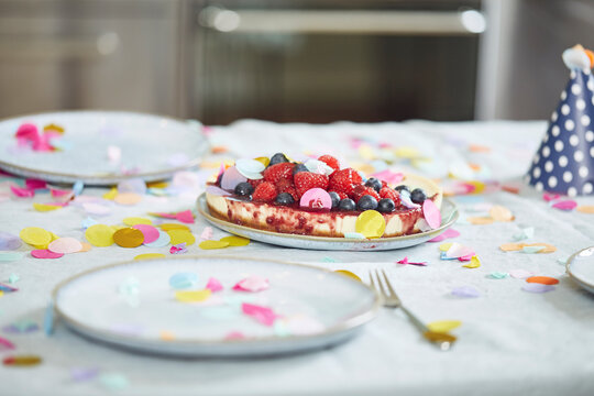 Birthday cake with berries on table