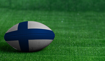 Fototapeta na wymiar American football ball with Finland flag on green grass background, close up