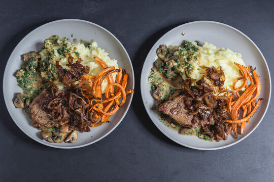 Beef sirloin steak with mushroom-mustard sauce, mashed potatoes, braised onions and carrot strips