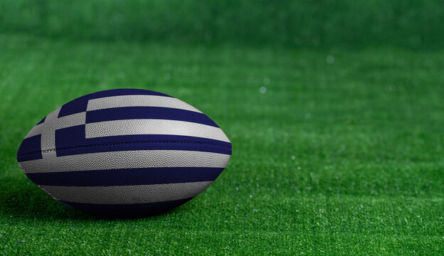 American football ball  with Greece flag on green grass background, close up