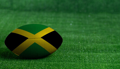 American football ball  with Jamaica flag on green grass background, close up