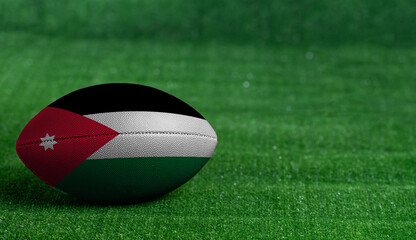 Fototapeta na wymiar American football ball with Jordan flag on green grass background, close up