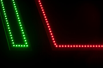 Dark background Detail of a neon sign made of green and red LEDs with copyspace