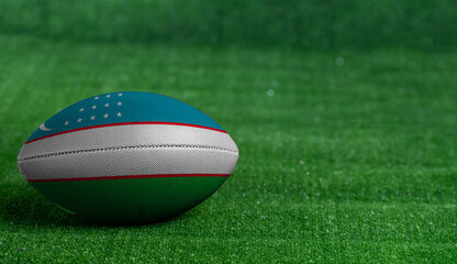 American football ball  with Uzbekistan flag on green grass background, close up