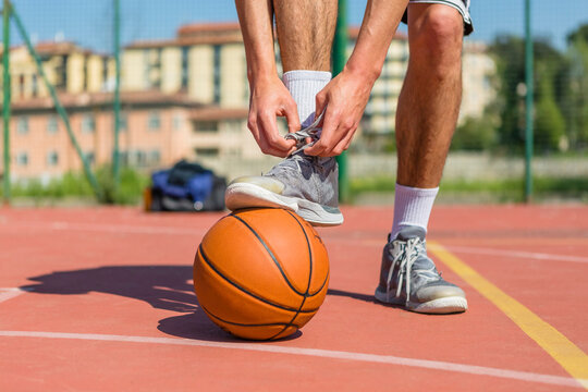 Young basketball player tying shoes - Powered by Adobe