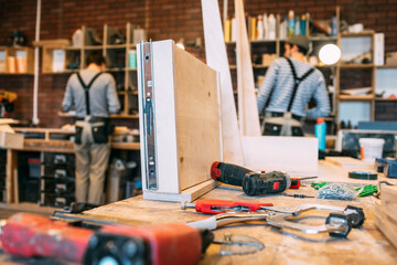 Carpenters at work, drawer in the foreground