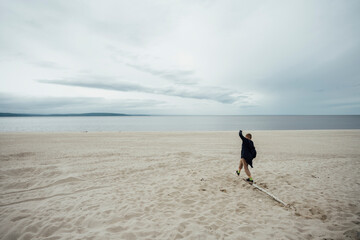 Portrait of happy blond boy with freckles wearing hooded jacket in front of Zeya River, Russia