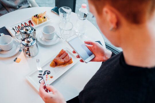 Close-up of young woman using smartphone in a cafe