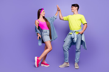 Photo of positive buddie couple high-five team win concept wear pin-up outfit isolated purple color...
