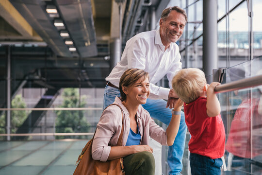 Happy family at the airport looking out of window