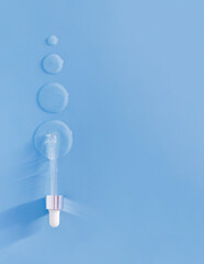pipette drops of serum on blue background	
