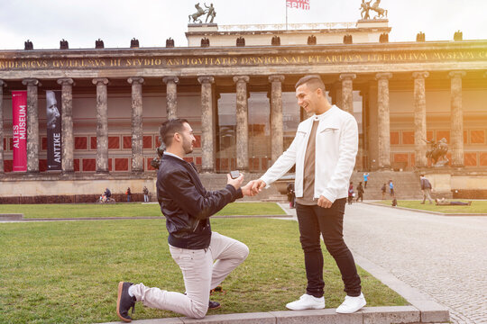 Young man proposing to his surprised boyfriend at Lustgarten, Berlin, Germany