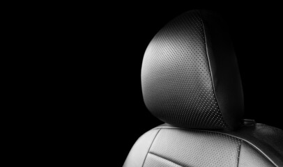 Modern luxury car black perforated leather interior. Part of black leather car seat details with...