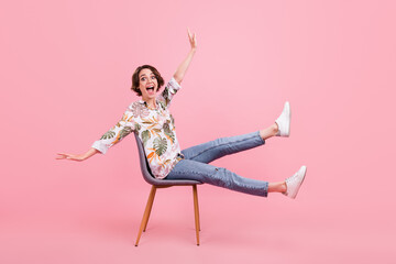 Full length body size photo woman sitting on chair laughing overjoyed isolated pastel pink color...