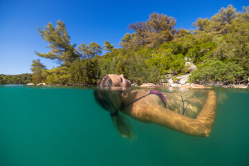 Underwater photo of a girl swimming on the marine lake on Mljet island, Croatia