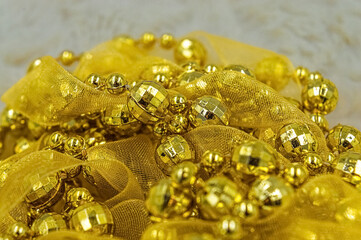 Pile of yellow New Year's and Christmas decorations with beads and ribbon