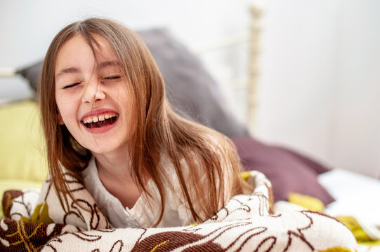 Portrait Of Laughing Girl Lying On Bed