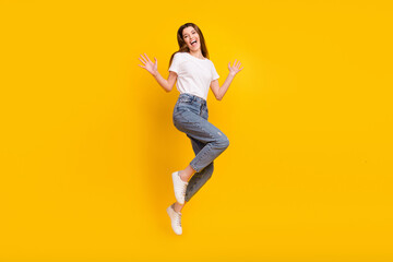 Fototapeta na wymiar Full size photo of positive excited happy woman jump up hands good mood isolated on yellow color background