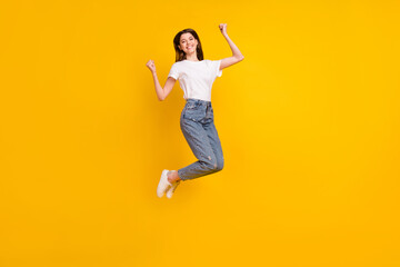 Fototapeta na wymiar Full body photo of cheerful young happy woman jump up winner celebrate isolated on yellow color background