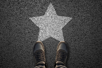 White star shape with shoes on the asphalt ground