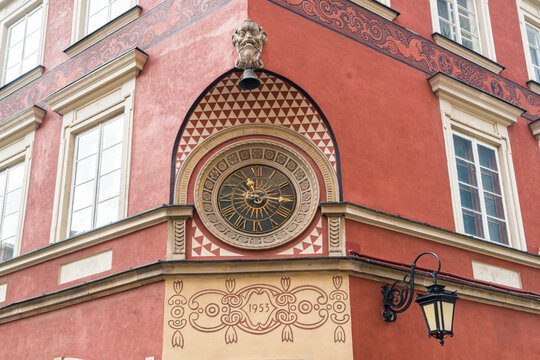 Ornamented historic clock at facade of a house at market square in the old town, Warsaw, Poland