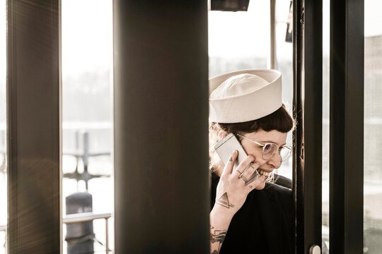 Woman with a sailor's hat using smartphone on a houseboat