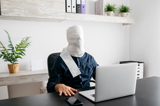 Man working at home with his head covered in toilet paper