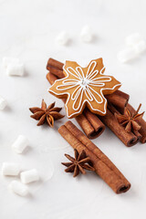 Obraz na płótnie Canvas Christmas composition made of gingerbread snowflake, cinnamon sticks, anise stars and marshmallow on a white background.