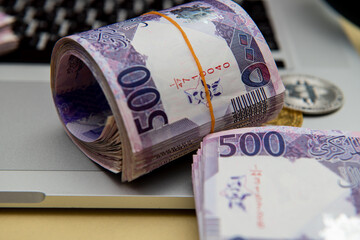 Bitcoin Cryptocurrency on Qatari 500 Riyal banknotes. Selective focus. business and Finance 