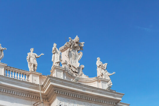 Italy, Rome, Low angle view of sculptures standing on top of colonnade of Saint Peters Square