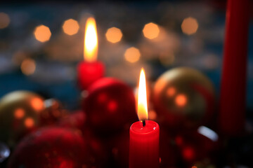 Red burning advent candles and Christmas baubles