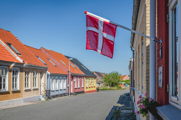 Denmark, Region of Southern Denmark, Marstal, Danish flag hanging over empty town street