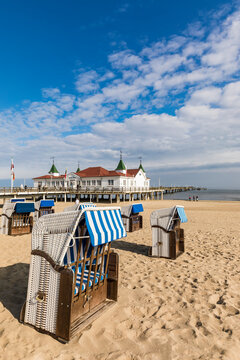 Germany,&Ocirc;&oslash;&Omega;Mecklenburg-Western&Ocirc;&oslash;&Omega;Pomerania, Heringsdorf, Hooded beach chairs on sandy coastal beach with pier in background