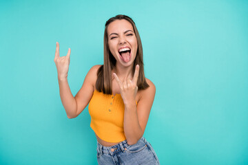 Photo of cheerful crazy happy young woman hold rock sign face stick out tongue cool isolated on teal color background