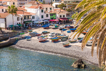 Portugal, Madeira, Camara de Lobos, Boats left on beach of coastal town in summer