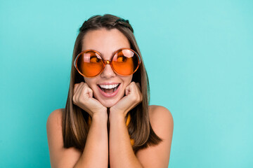 Photo of dreamy positive young happy woman hold hands face look empty space summer isolated on teal color background