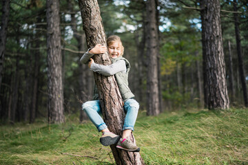 Girl hugging a tree in the forest