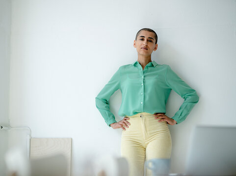 Portrait of a confident woman leaning against wall in a loft