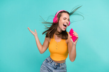 Portrait of excited overjoyed attractive girl hold telephone sing have fun good mood isolated on...