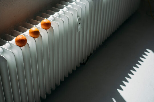 THree oranges on heater, ripening in the sun