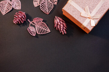 Christmas frame made of shiny gift boxes and decorations on a black background. Top view