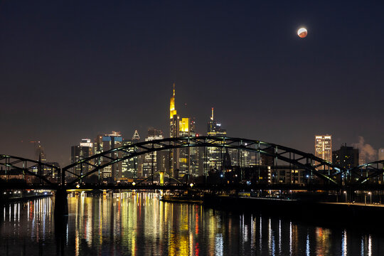 Germany, Frankfurt on Main, view to lighted skyline with Deutschherrn Bridge at total lunar eclipse